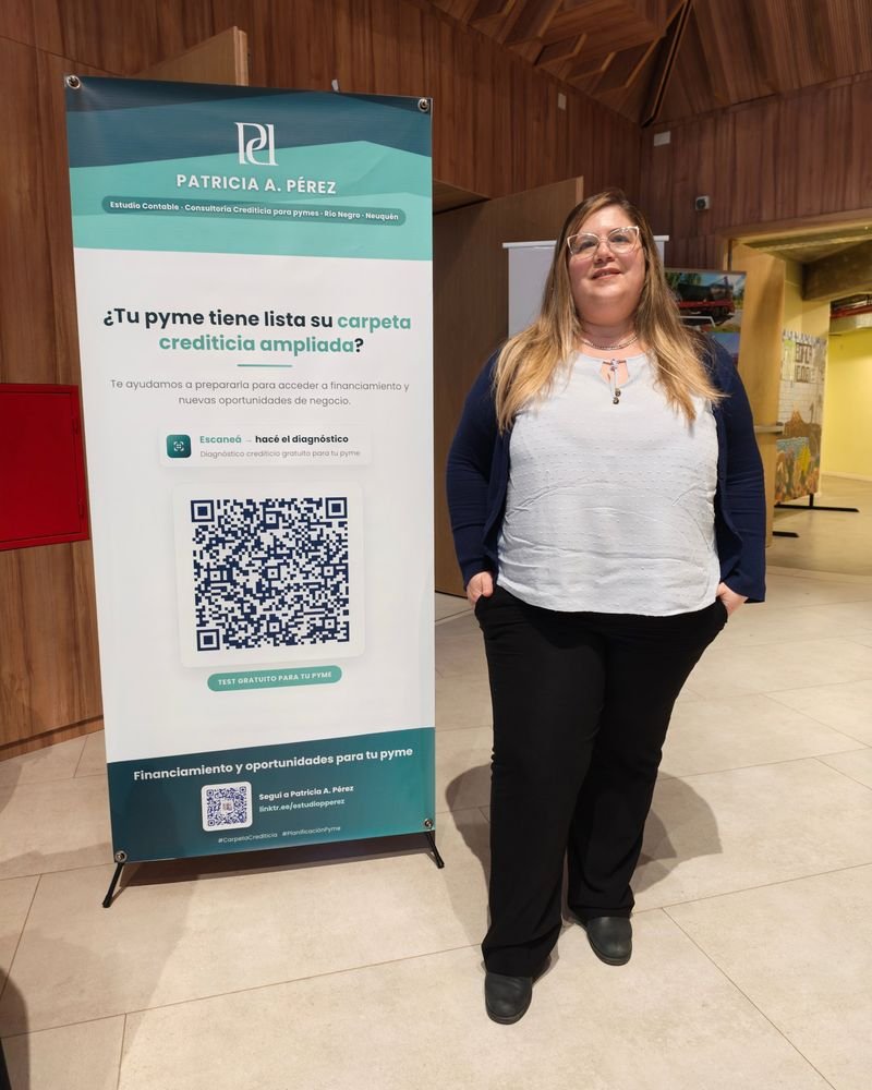 Integrante del estudio junto al banner del Estudio Patricia Pérez en un evento